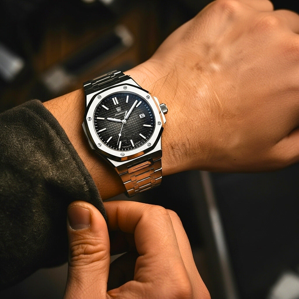 Close-up of a person wearing a luxury watch with a dark face and metallic band.
