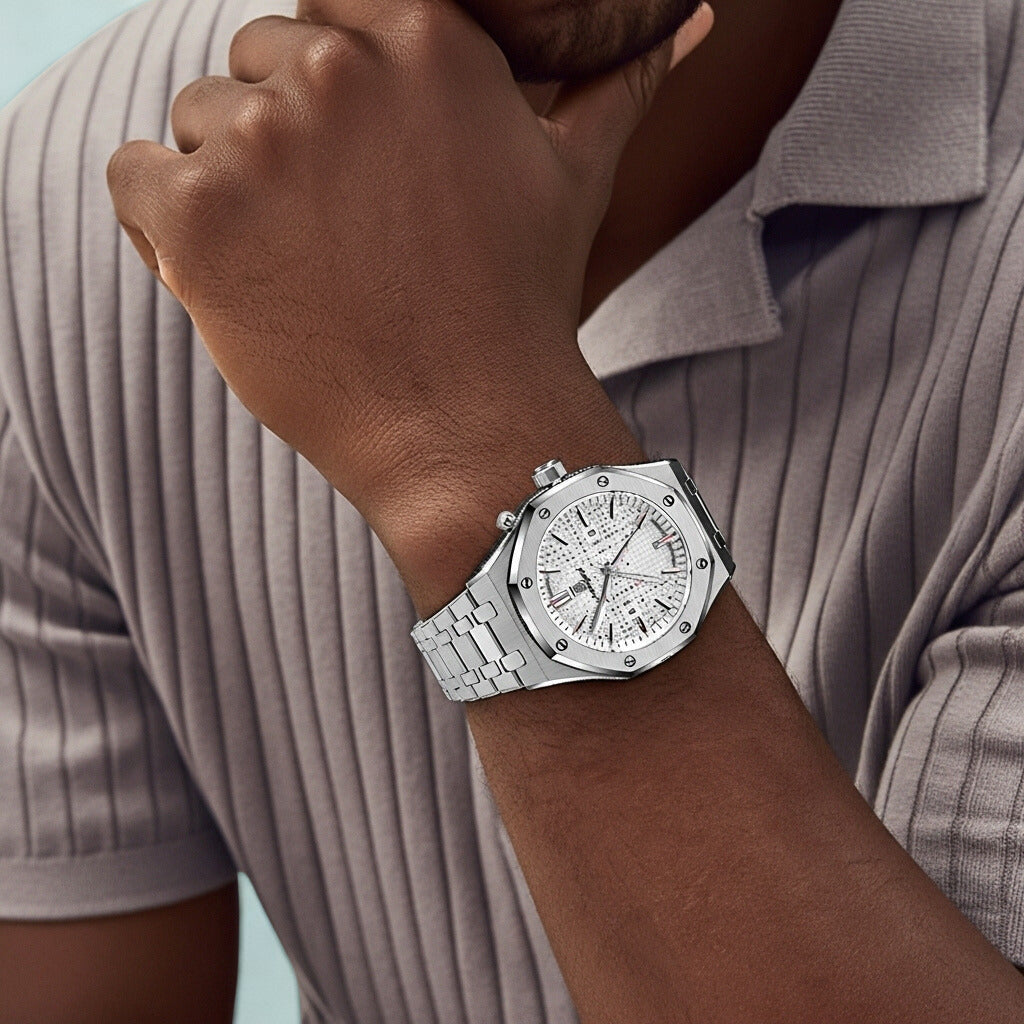 Silver watch on a wrist with a neutral background